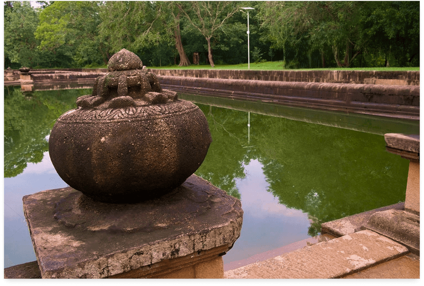 Ancient stone work by a tranquil waterway in Anuradhapura